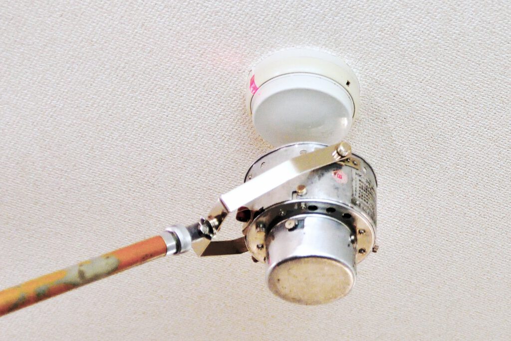 火災報知器を点検する作業員
